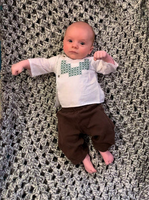 Baby wearing the embroidered Mexican Baby Shirt in white poplin.